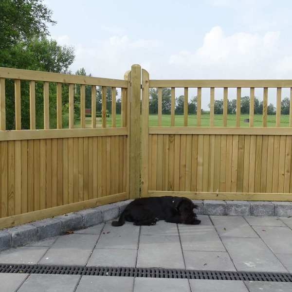 Ein Hund macht ein Nickerchen vor einem „Country Garden“-Zaun