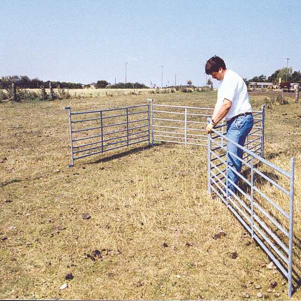 Ein Mann ist dabei, mobile Zaunelemente zu montieren.